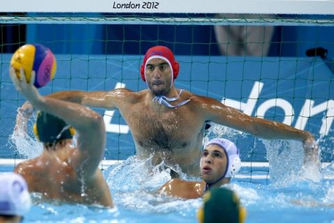 Jamie Beadsworth of Australia, left, scores a goal against Nikolaos Deligiannnis of Greece during a preliminary men's water polo match at the 2012 Summer Olympics, Monday, Aug. 6, 2012, in London. (AP Photo/Julio Cortez)