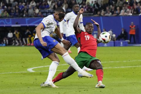 Kylian Mbappe of France, left, and Portugal's Nuno Mendes battle for the ball during a quarter final match at the Euro 2024 soccer tournament in Hamburg, Germany, Friday, July 5, 2024. (AP Photo/Hassan Ammar)