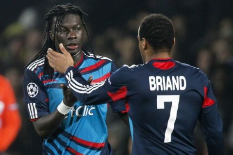 Olympique Lyon's Bafetimbi Gomis (C) celebrates with team mate Jimmy Briand after scoring against Real Madrid during their Champions League soccer match at the Gerland stadium in Lyon February 22, 2011.   REUTERS/Robert Pratta (FRANCE - Tags: SPORT SOCCER)