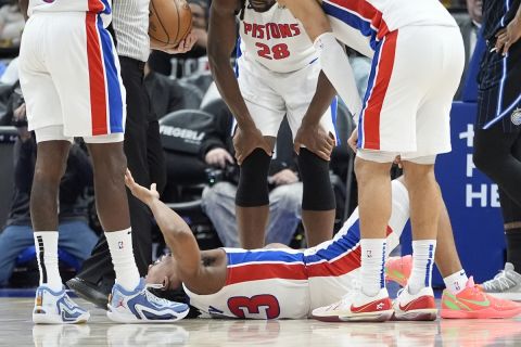 Teammates look over Detroit Pistons guard Jaden Ivey (23) after an incident during the second half of an NBA basketball game against the Orlando Magic, Wednesday, Jan. 1, 2025, in Detroit. Ivey was carted off the court by stretcher. (AP Photo/Carlos Osorio)