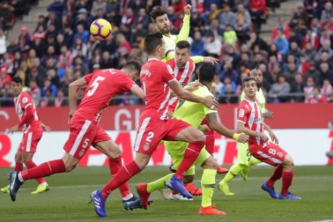 FC Barcelona's Gerard Pique, centre back, heads the ball during the Spanish La Liga soccer match between Girona and FC Barcelona and Girona at the Montilivi stadium in Girona, Spain, Sunday, Jan. 27, 2019. (AP Photo/Manu Fernandez)