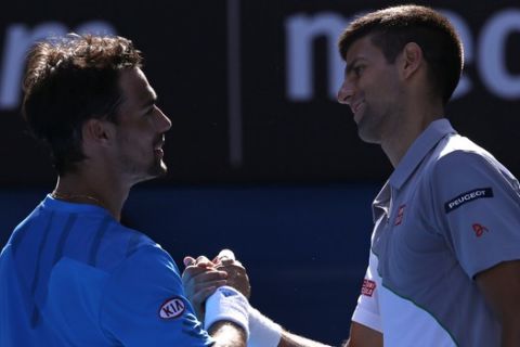 Novak Djokovic of Serbia, right, shakes hands with Fabio Fognini of Italy after Djokovic won their fourth round match at the Australian Open tennis championship in Melbourne, Australia, Sunday, Jan. 19, 2014.(AP Photo/Eugene Hoshiko)