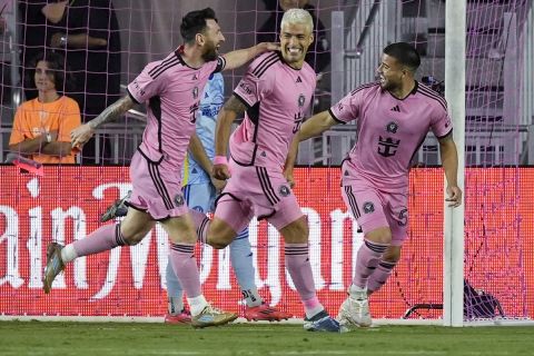 Inter Miami forward Luis Suarez (9), center, is congratulated by his teammates after scoring a goal during the first half of an MLS playoff soccer match against the Atlanta United, Friday, Oct. 25, 2024, in Fort Lauderdale, Fla. (AP Photo/Rebecca Blackwell)