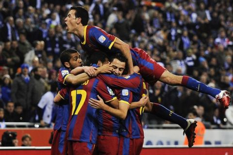 BARCELONA, SPAIN - DECEMBER 18:  Sergio Busquets jumps on his team mates as he celebrates his team's first goal scored by Pedro Rodriguez of Barcelona during the La Liga match between Espanyol and Barcelona at Cornella - El Prat stadium on December 18, 2010 in Barcelona, Spain.  (Photo by David Ramos/Getty Images)