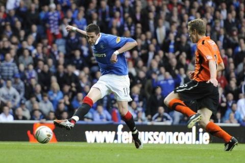 Rangers' Kyle Lafferty (L) scores a goal as Dundee United's Paul Dixon challenges during their Scottish Premier League soccer match at Ibrox Stadium, Glasgow, Scotland, May 10, 2011. REUTERS/Russell Cheyne (BRITAIN - Tags: SPORT SOCCER)