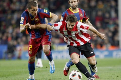 Barcelona's Dani Alves (L) challenges for the ball against Athletic Bilbao's Koikili during their Spanish first division soccer match at Nou Camp stadium in Barcelona February 20, 2011. REUTERS/Gustau Nacarino (SPAIN - Tags: SPORT SOCCER)