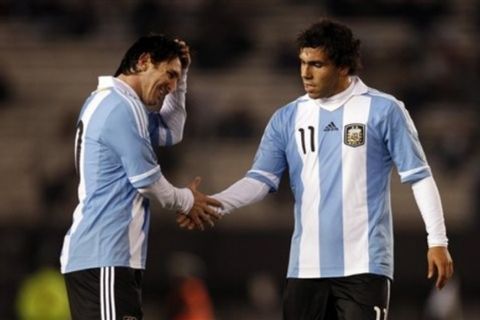 Argentina Carlos Tevez, right, shakes hands with teammate Lionel Messi at a friendly soccer match against Albania ahead of the upcoming 2011 Copa America in Buenos Aires, Argentina, Monday, June 20, 2011. (AP Photo/Natacha Pisarenko)