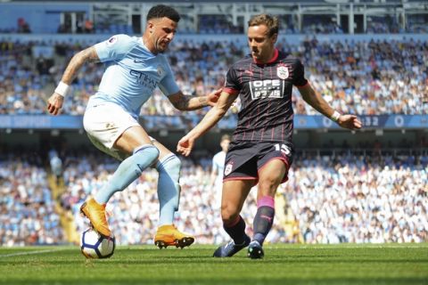 Manchester City's Kyle Walker, left, and Huddersfield's Chris Lowe vie for the ball during the English Premier League soccer match between Manchester City and Huddersfield Town at Etihad stadium in Manchester, England, Sunday, May 6, 2018. (AP Photo/Rui Vieira)