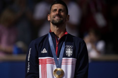 Serbia's Novak Djokovic poses with his gold medal after defeating Spain's Carlos Alcaraz during the men's singles tennis final at the Roland Garros stadium during the 2024 Summer Olympics, Sunday, Aug. 4, 2024, in Paris, France. Djokovic has won his first Olympic gold medal by beating Alcaraz 7-6 (3), 7-6 (2) in the 2024 Games men's tennis singles final. (AP Photo/Louise Delmotte)