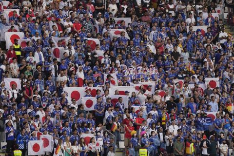 Japan supporters wave flags prior to the World Cup group E soccer match between Germany and Japan, at the Khalifa International Stadium in Doha, Qatar, Wednesday, Nov. 23, 2022. (AP Photo/Eugene Hoshiko)