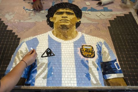 Artists construct a tile mosaic of soccer legend Diego Maradona during a celebration marking the anniversary of the Hand of God goal and the Goal of the Century scored by Maradona against England during the 1986 World Cup quarterfinals, in Buenos Aires, Argentina, Saturday, June 22, 2024. Maradona, who died in 2020 at age 60, captained Argentina in its 3-2 win over West Germany in the 1986 final in Mexico City.  (AP Photo/Rodrigo Abd)