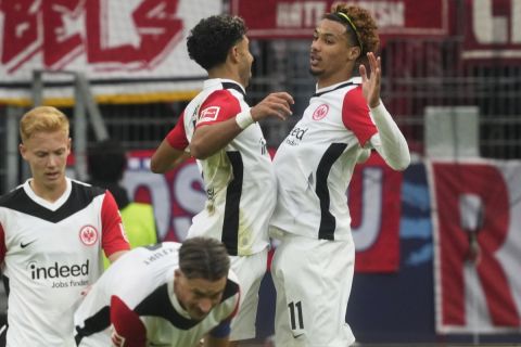 Frankfurt's Hugo Ekitike, right, celebrates after scoring his side's second goal during the German Bundesliga soccer match between Eintracht Frankfurt and Bayern Munich in Frankfurt, Germany, Sunday, Oct. 6, 2024. (AP Photo/Michael Probst)