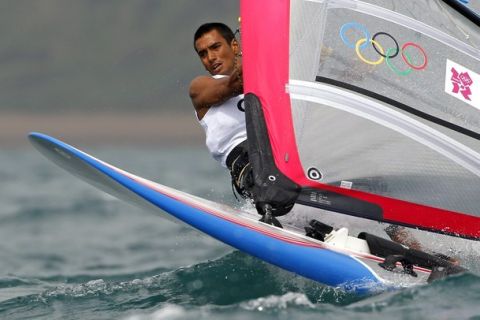 Greece's Byron Kokalanis stands on his windsurfing board during the first race of the RS-X class at the London 2012 Olympic Games in Weymouth and Portland, southern England, July 31, 2012. REUTERS/Benoit Tessier (BRITAIN  - Tags: SPORT YACHTING SPORT OLYMPICS)