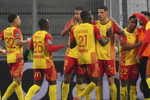 Lens' Wesley Said, centre right, celebrates after scoring his side's opening goal during a French League One soccer match between Marseille and Lens at the Stade Velodrome stadium in Marseille, France, Sunday, April 28, 2024. (AP Photo/Daniel Cole)