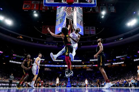 Philadelphia 76ers' Joel Embiid, center right, dunks the ball against Cleveland Cavaliers' Jarrett Allen, center left, during the first half of an NBA basketball game, Saturday, Feb. 12, 2022, in Philadelphia. (AP Photo/Chris Szagola)