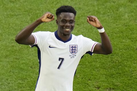 England's Bukayo Saka celebrates after scoring his side's opening goal during a quarterfinal match between England and Switzerland at the Euro 2024 soccer tournament in Duesseldorf, Germany, Saturday, July 6, 2024. (AP Photo/Hassan Ammar)