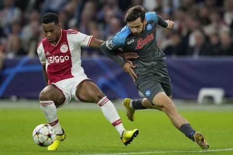 Napoli's Khvicha Kvaratskhelia, right, challenges Ajax's Jurrien Timber during the Champions League group A soccer match between Ajax and Napoli at the Johan Cruyff ArenA in Amsterdam, Netherlands, Tuesday, Oct. 4, 2022. (AP Photo/Peter Dejong)