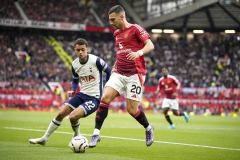 Tottenham's Brennan Johnson, left, challenges for the ball with Manchester United's Diogo Dalot during the English Premier League soccer match between Manchester United and Tottenham Hotspur at Old Trafford stadium in Manchester, England, Sunday, Sept. 29, 2024. (AP Photo/Dave Thompson)