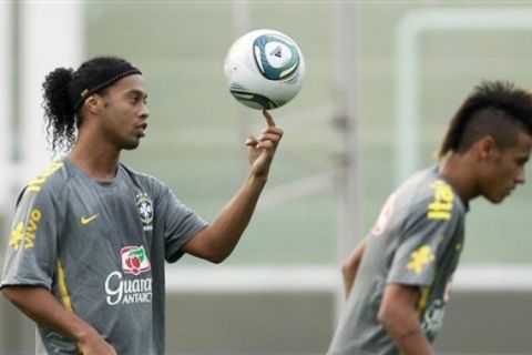 Brazil's Ronaldinho, left, balances the ball on his finger as teammate Neymar walks by during a training session in Cordoba, Argentina, Tuesday Sept. 13, 2011. Brazil will face Argentina in a friendly soccer match on Wednesday. (AP Photo/Victor R. Caivano)