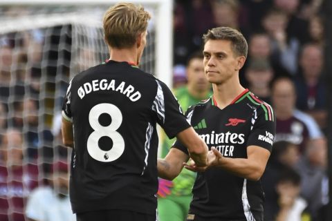 Arsenal's Leandro Trossard, right, celebrates with Arsenal's Martin Odegaard after scoring his side's opening goal during the English Premier League soccer match between Aston Villa and Arsenal at Villa Park in Birmingham, England, Saturday, Aug. 24, 2024. (AP Photo/Rui Vieira)