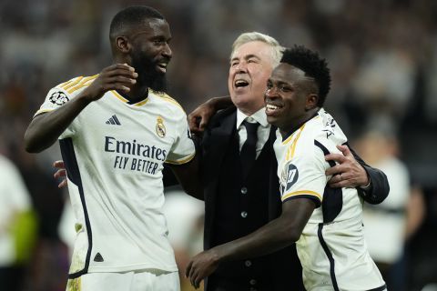 Real Madrid's head coach Carlo Ancelotti, centre, celebrates with his players Vinicius Junior, right, and Antonio Rudiger after winning the Champions League semifinal second leg soccer match between Real Madrid and Bayern Munich at the Santiago Bernabeu stadium in Madrid, Spain, Wednesday, May 8, 2024. Real Madrid won 2-1. (AP Photo/Jose Breton)