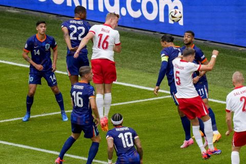 Poland's Adam Buksa, centre, scores his side's opening goal during a Group D match between Poland and the Netherlands at the Euro 2024 soccer tournament in Hamburg, Germany, Sunday, June 16, 2024. (AP Photo/Petr Josek)