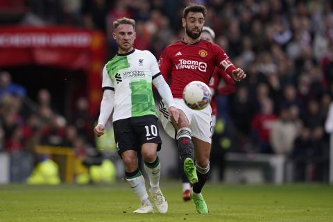 Liverpool's Alexis Mac Allister, left, is challenged by Manchester United's Bruno Fernandes during the FA Cup quarterfinal soccer match between Manchester United and Liverpool at the Old Trafford stadium in Manchester, England, Sunday, March 17, 2024. (AP Photo/Dave Thompson)