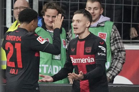 Leverkusen's Florian Wirtz, right, celebrates with Amine Adli after scoring his side's second goal during the German Bundesliga soccer match between Bayer Leverkusen and VfL Wolfsburg at the BayArena in Leverkusen, Germany, Sunday, March 10, 2024. (AP Photo/Martin Meissner)