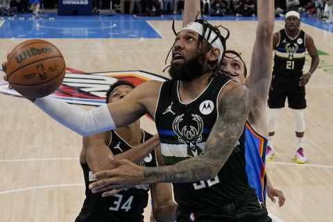 Milwaukee Bucks guard DeAndre' Bembry goes to the basket in front of Oklahoma City Thunder forward Isaiah Roby (22), guard Tre Mann (23) and center Aleksej Pokusevski, right, in the first half of an NBA basketball game Tuesday, March 8, 2022, in Oklahoma City. (AP Photo/Sue Ogrocki)