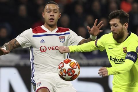 Lyon forward Memphis Depay, left, challenges Barcelona forward Lionel Messi, right, during the Champions League round of 16 first leg soccer match between Lyon and FC Barcelona in Decines, near Lyon, central France, Tuesday, Feb. 19, 2019. (AP Photo/Laurent Cipriani)