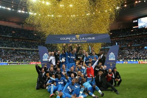 Olympique de Marseille's players pose with their trophies after winning the French League Cup Final football match Lyon vs. Marseille at the Stade de France in Saint-Denis, north of Paris.Marseille won 0-1.  AFP PHOTO / KENZO TRIBOULLIARD (Photo credit should read KENZO TRIBOULLIARD/AFP/Getty Images)