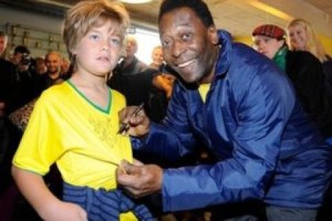 Brazilian soccer legend Pele signs the shirt of 8-year old Max Sehested before a practice session in Copenhagen, Tuesday Sept. 29, 2009. Rio de Janeiro  is competing with Chicago, Madrid, Tokyo for the right to host the 2016 Summer Olympic Games. The IOC will choose the winning city in a vote on Friday in Copenhagen. (AP Photo/Fabian Bimmer)