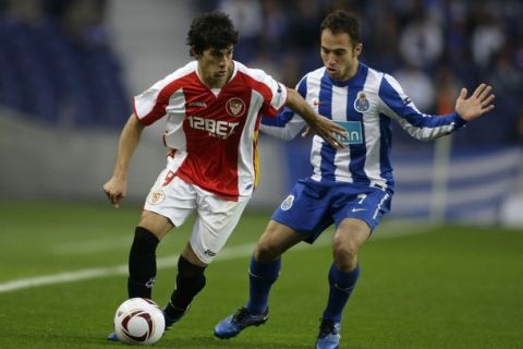 Porto's Fernando Belluschi (R) battles for the ball with Sevilla's Diego Perotti during their Europa League round of 32, second leg soccer match at Dragao stadium in Porto February 23, 2011. REUTERS/Miguel Vidal (PORTUGAL - Tags: SPORT SOCCER)