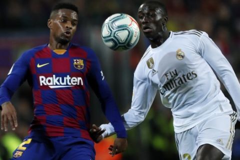 Barcelona's Nelson Semedo, left, and Real Madrid's Ferland Mendy fight for the ball during a Spanish La Liga soccer match between Barcelona and Real Madrid at Camp Nou stadium in Barcelona, Spain, Wednesday, Dec. 18, 2019. Thousands of Catalan separatists are planning to protest around and inside Barcelona's Camp Nou Stadium during Wednesday's "Clasico". (AP Photo/Joan Monfort)