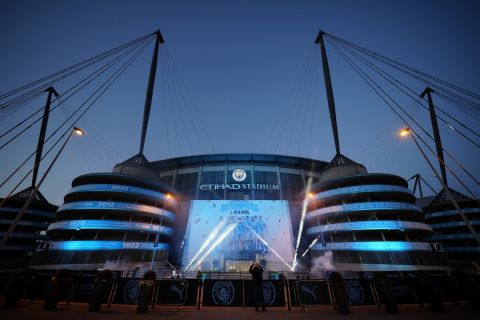 A banner celebrating their title win is illuminated outside Manchester City's Etihad stadium in Manchester, England, Saturday, May 20, 2023. Manchester City clinched the English Premier League title on Saturday after their nearest challengers Arsenal lost 1-0 to Nottingham Forest. (AP Photo/Jon Super)