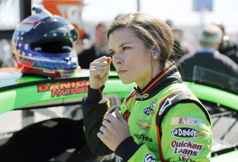 Danica Patrick removes her earplugs by her car on pit road after qualifying for the NASCAR Daytona 500 Sprint Cup Series auto race at Daytona International Speedway, Sunday, Feb. 17, 2013, in Daytona Beach, Fla. Patrick won the pole, becoming the first woman to secure the top spot for any Sprint Cup race. (AP Photo/Terry Renna) ** Usable by LA and DC Only **