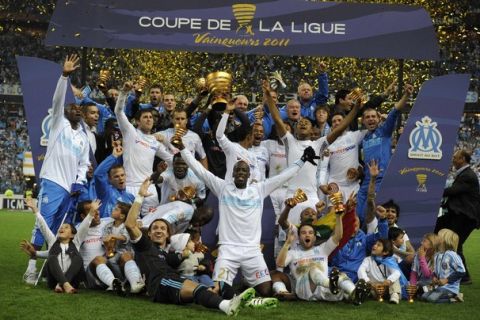 Marseille's players celebrate with their trophy after winning the French soccer League Cup final match against Montpellier at the Stade de France in Saint-Denis near Paris, April 23, 2011.  REUTERS/Gonzalo Fuentes (FRANCE - Tags: SPORT SOCCER)