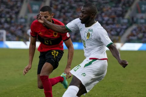 Mauritania's Aboubakary Koita, right, is challenged by Angola's Eddie Afonso during the African Cup of Nations Group D soccer match between Mauritania and Angola at the Bouake stadium in Bouake, Ivory Coast, Saturday, Jan. 20, 2024. (AP Photo/Themba Hadebe)