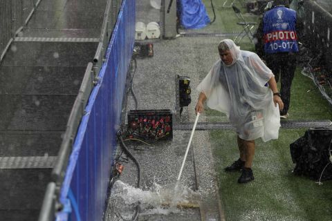 Μέλη της διοργάνωσης προσπαθούν να καθαρίσουν τα νερά από το γήπεδο