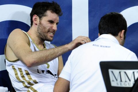 Real Madrid's guard Rudy Fernandez (L) gets help after suffering an injury during the Euroleague basketball match Real Madrid vs Belgacom Spirou on November 24, 2011 at La Caja Magica Arena in Madrid.  AFP PHOTO/ JAVIER SORIANO (Photo credit should read JAVIER SORIANO/AFP/Getty Images)