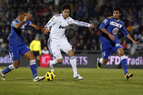 Real Madrid's Kaka (C) is challenged by Getafe's Daniel Alberto Diaz (L) and Miguel Torres Gomez during their Spanish first division soccer league match at the Colisseum Alfonso Perez stadium in Madrid January 3, 2011. REUTERS/Juan Medina (SPAIN - Tags: SPORT SOCCER)