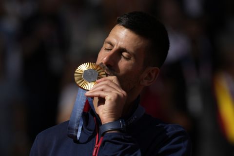 Serbia's Novak Djokovic kisses his gold medal after defeating Spain's Carlos Alcaraz during the men's singles tennis final at the Roland Garros stadium during the 2024 Summer Olympics, Sunday, Aug. 4, 2024, in Paris, France. Djokovic has won his first Olympic gold medal by beating Alcaraz 7-6 (3), 7-6 (2) in the 2024 Games men's tennis singles final. (AP Photo/Louise Delmotte)