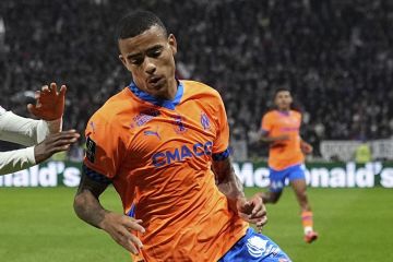 Marseille's Mason Greenwood, right, challenges Lyon's Clinton Mata  for the ball during a French League One soccer match at the Groupama stadium in Decines, outside Lyon, France, Sunday, Sept. 22, 2024. (AP Photo/Laurent Cipriani)