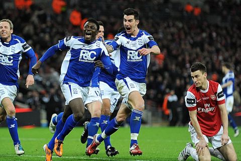 Soccer - Carling Cup - Final - Arsenal v Birmingham City - Wembley Stadium.Arsenal's Laurent Koscielny (right) is left dejected as Birmingham City's Obafemi Martins (centre) celebrates wildly with team-mates after scoring their second goal of the game URN:10274220