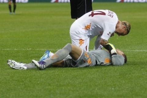 AS Roma goalkeeper Maarten Stekeleburg of The Netherlands lies on the ground and is helped by his teammate AS Roma defender Simon Kjaer of Denmark after he was injured during a Serie A soccer match between Inter Milan and AS Roma at the San Siro stadium in Milan, Italy, Saturday, Sept.17, 2011. (AP Photo/Luca Bruno)