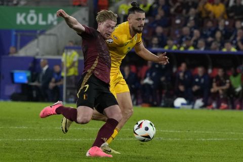 Belgium's Kevin De Bruyne, left, scores his side's second goal during a Group E match between Belgium and Romania at the Euro 2024 soccer tournament in Cologne, Germany, Saturday, June 22, 2024. (AP Photo/Alessandra Tarantino)