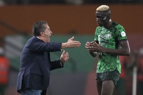 Nigeria's head coach Jose Peseiro talks to Nigeria's Victor Osimhen during the African Cup of Nations quarterfinal soccer match between Nigeria and Angola, at the Felix Houphouet Boigny stadium in Abidjan, Ivory Coast, Friday, Feb. 2, 2024. 2024. (AP Photo/Sunday Alamba)