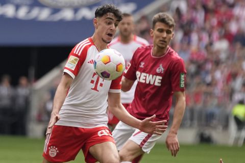 Bayern's Aleksandar Pavlovic is challenged by Cologne's Dejan Ljubicic, right, during the German Bundesliga soccer match between Bayern Munich and Cologne at the Allianz Arena in Munich, Germany, Saturday, April 13, 2024. (AP Photo/Matthias Schrader)