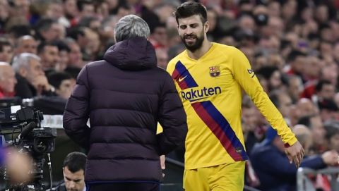 Barcelona's head coach Quique Setien, left, speaks with Barcelona's Gerard Pique as he is substituted during the Spanish Copa del Rey, quarter final, soccer match between Athletic Bilbao and Barcelona at San Mames stadium in Bilbao, Spain, Thursday, Feb. 6, 2020. (AP Photo/Alvaro Barrientos)