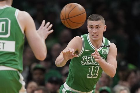 Boston Celtics guard Payton Pritchard (11) passes the ball to forward Luke Kornet, left, in the second half of an NBA basketball game against the Washington Wizards, Sunday, April 3, 2022, in Boston. The Celtics won 144-102. (AP Photo/Steven Senne)